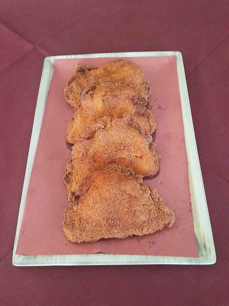 Vassoio con quattro cotolette impanate alla lubianese su carta rossa