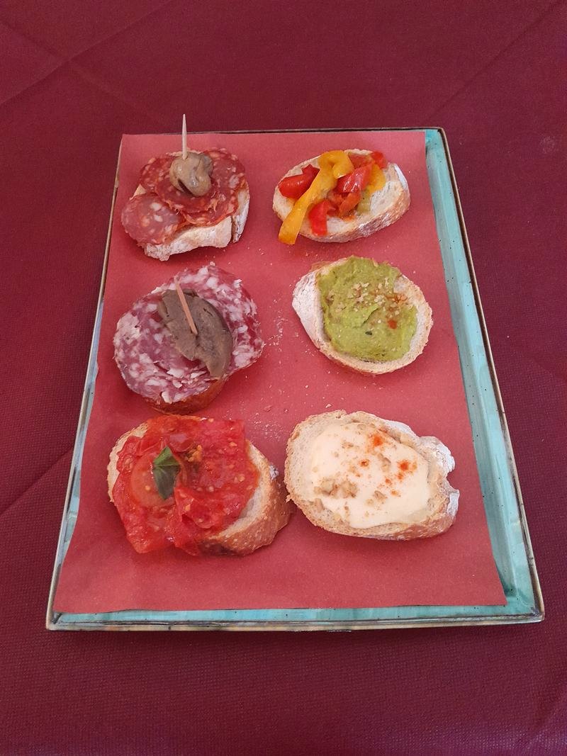 Vassoio con sei tartine assortite: salame con funghetto, peperoni, crema verde, pomodoro e formaggio